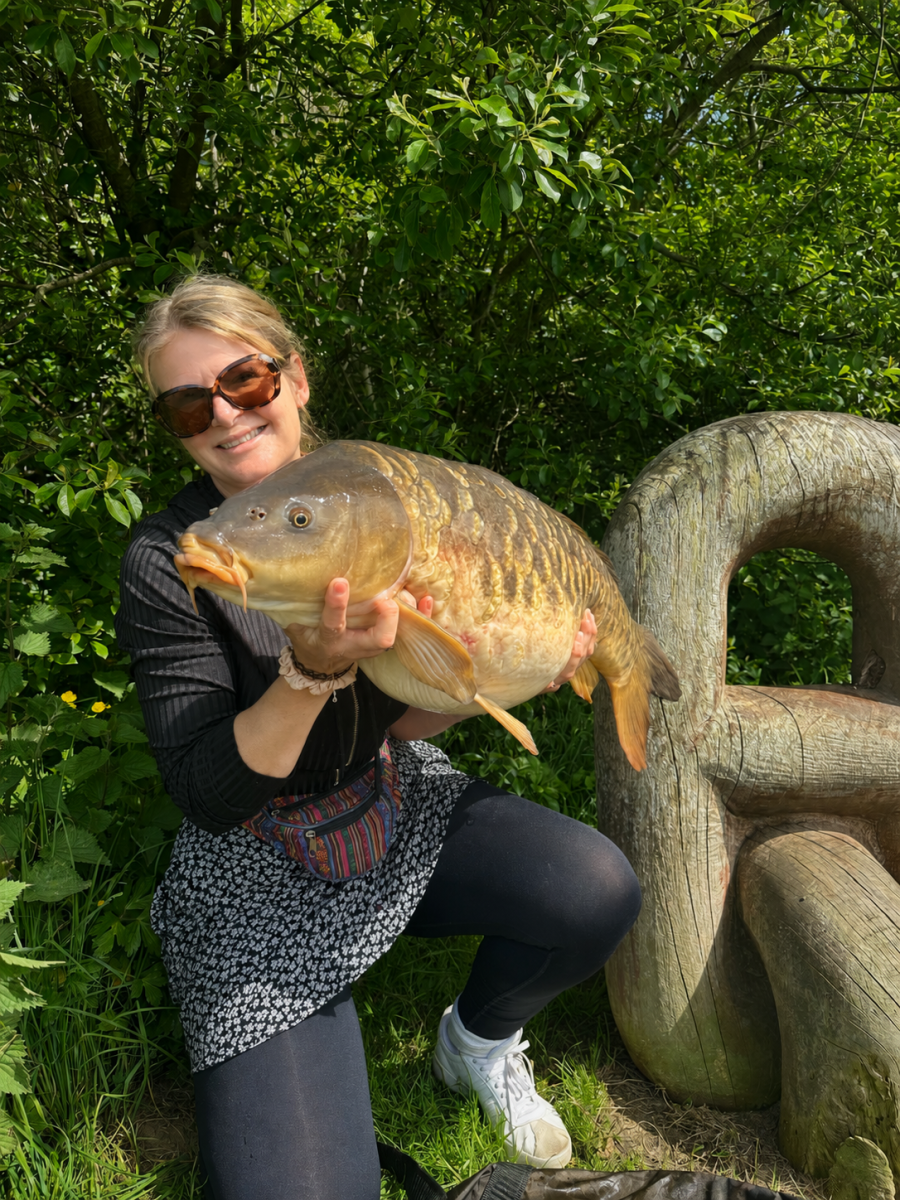 A superb mirror carp caught by Louise Banks using a dog treat weighing in at 24lb 3oz